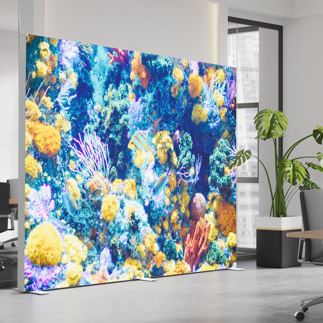 Beleuchtete BIG LEDUP Messewand mit farbenprächtigem Korallenriff-Motiv, aufgestellt in einem modernen Büro mit Pflanzen und großen Fenstern.