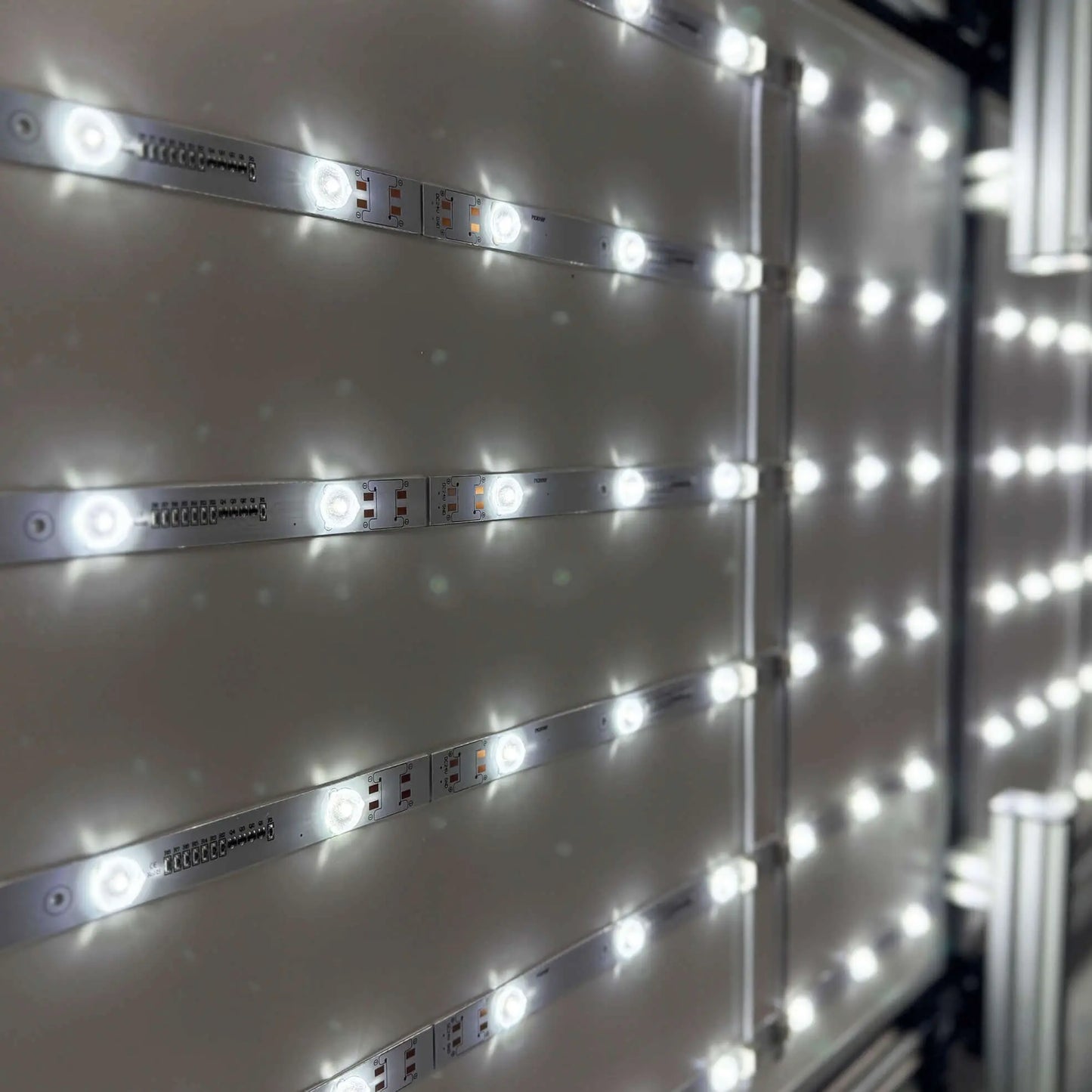 Nahaufnahme des Innenlebens eines LED-Rahmens mit sichtbarer Beleuchtungstechnik.