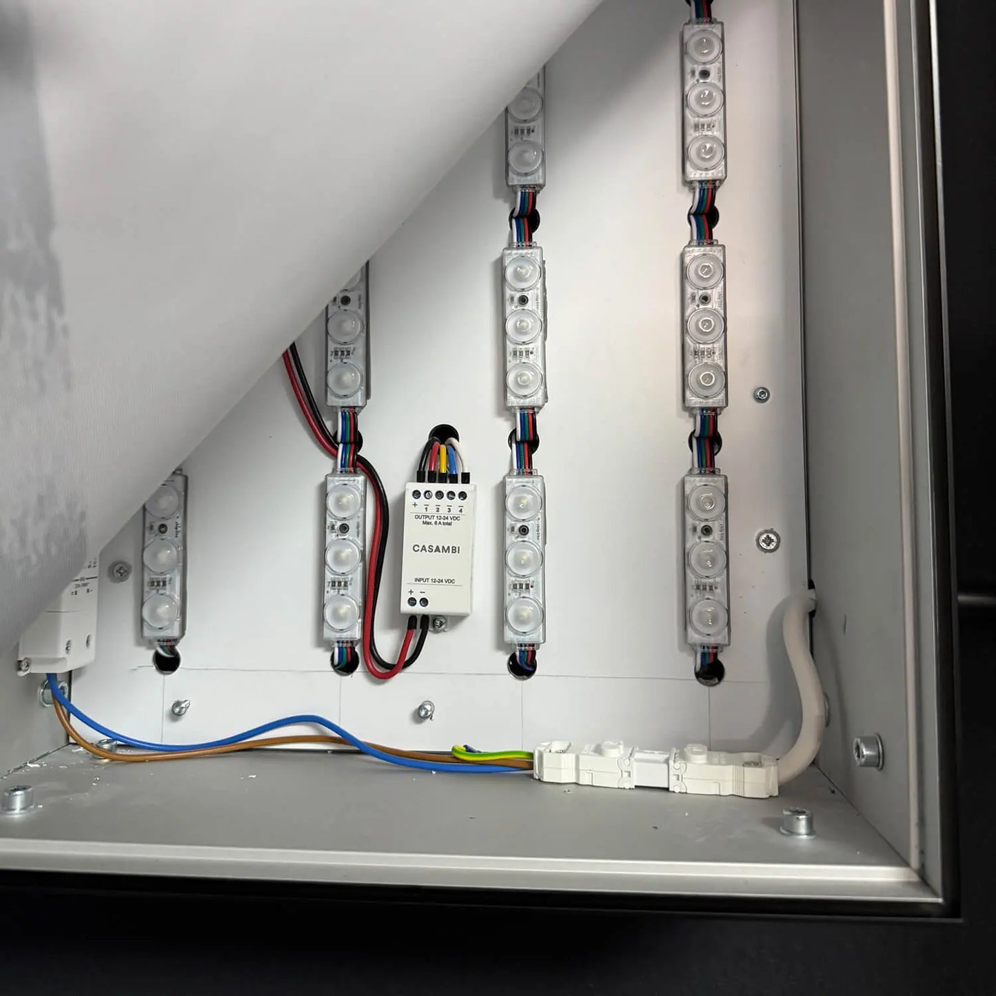 Geöffneter LED-Rahmen mit sichtbarer RGBW-Technik, darunter LED-Module, Kabel und Steuerungseinheit.