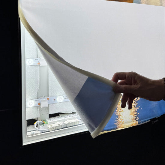 Darstellung eines Textildrucks, wie er von einem Textilspannrahmen abgezogen wird, mit Blick auf die LED-Technik und die Akustikmatte auf der Rückseite.