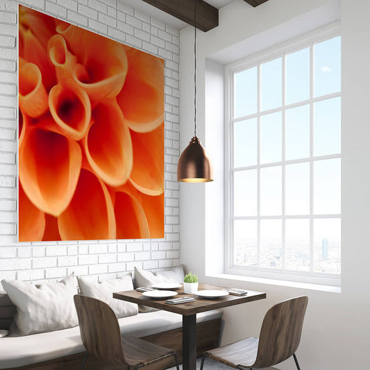 Quadratisches Akustikbild einer Makroaufnahme einer orangen Dahlie, über einem Esstisch