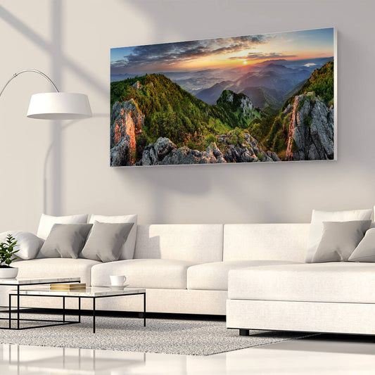 Rechteckiges Akustikbild eines grünen Gebiergszuges vor Sonnenuntergang, über einem weißen Sofa