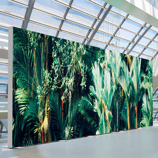 Beleuchtete BIG LEDUP Messewand mit Dschungelmotiv im modernen Glasgebäude.