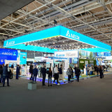 LED Messe-Deckenhänger in Quaderform mit umlaufender Markenbeschriftung über einem Messestand. Auffällige Sichtlösung für maximale Fernwirkung auf Messen und Events