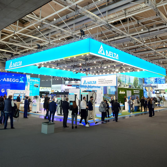 LED Messe-Deckenhänger in Quaderform mit umlaufender Markenbeschriftung über einem Messestand. Auffällige Sichtlösung für maximale Fernwirkung auf Messen und Events