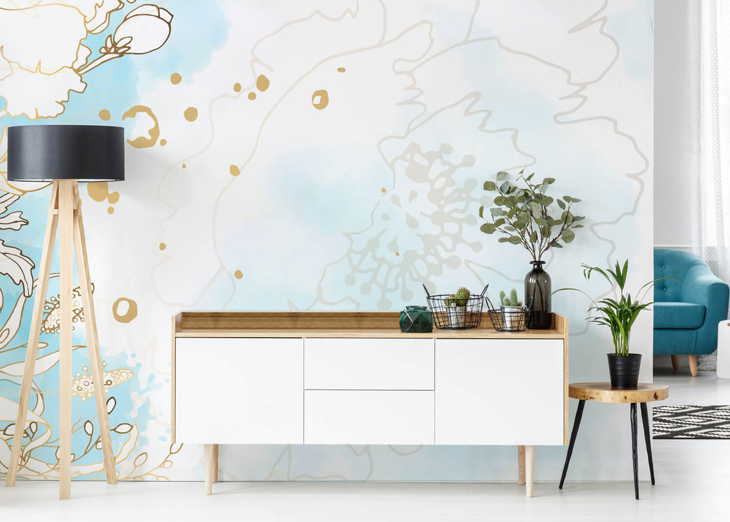 Die Wandverkleidung hinter dem Sideboard im Home & Living-Bereich ist in Hellblau und Weiß gestaltet und zeigt ein Motiv in Blumenoptik.