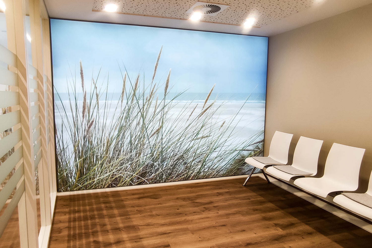 Wartebereich im medizinischen Bereich mit LED-Lichtwand mit Strand- und Gras-Motiv.