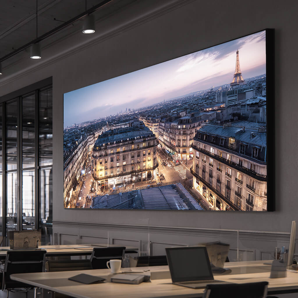 Großformatige Lummea Pro Lichtwand mit Paris-Stadtmotiv in einem modernen Büro. Elegante Integration in die Innenarchitektur für hochwertige Marken- und Rauminszenierung.