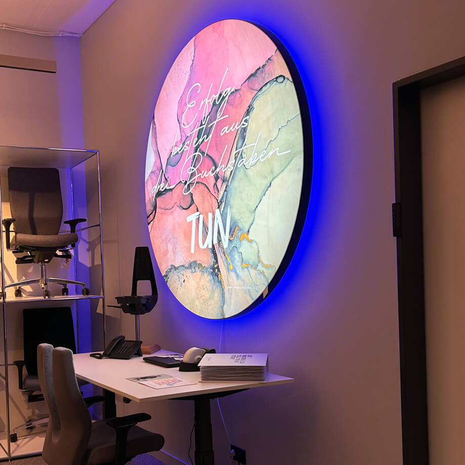 Beleuchtetes rundes Akustikbild mit Corona an der Wand zur Verbesserung er Raumakustik mit Ambientebeleuchtung