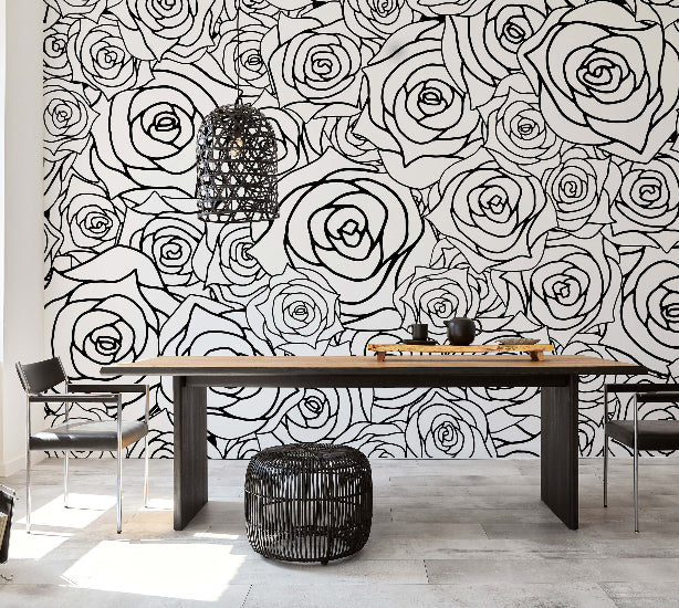 Essbereich mit moderner Wandverkleidung im großflächigen Rosendesign in Schwarz-Weiß, kombiniert mit einem schlichten Holztisch und schwarzen Stühlen.