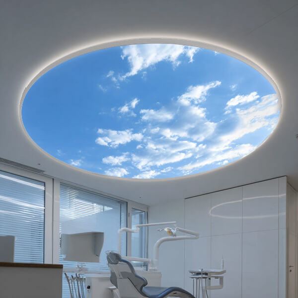 Runde LED-Lichtdecke mit Himmelmotiv in einer modernen Zahnarztpraxis, die für eine helle und beruhigende Atmosphäre sorgt.