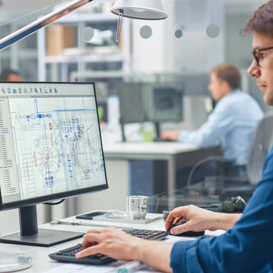 Darstellung einer technischen Zeichnung, während ein Mann am PC arbeitet.“